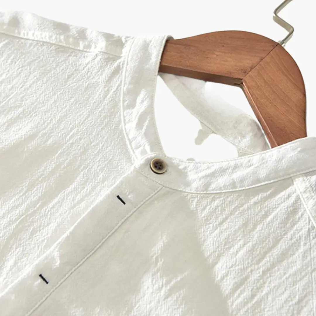 Light-weight white short-sleeve shirt with stand-up collar on wooden hanger
