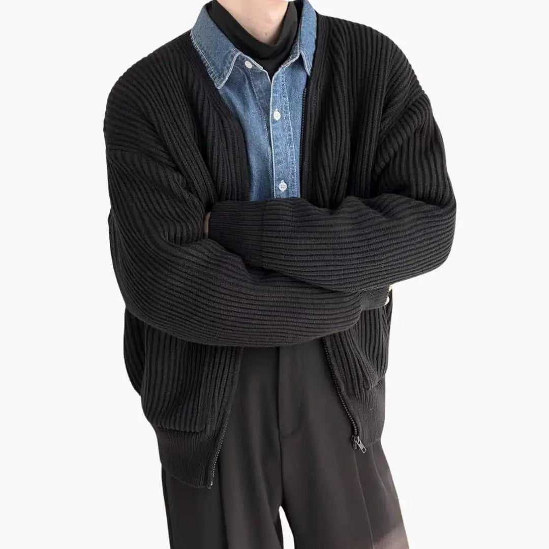 Men's black ribbed cardigan layered over a blue denim shirt