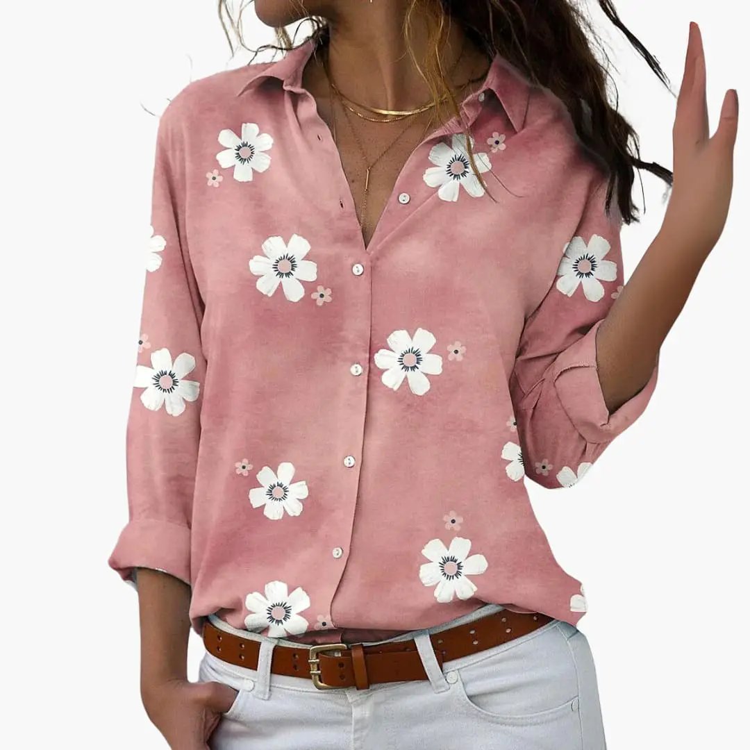 Floral blouse in pink with white daisies, button-front, rolled sleeves, paired with light jeans and brown belt.