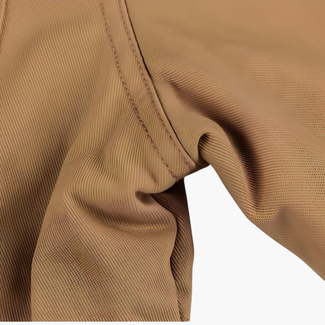 Men's jacket with zipper and multiple pockets in tan fabric, close-up stitching.