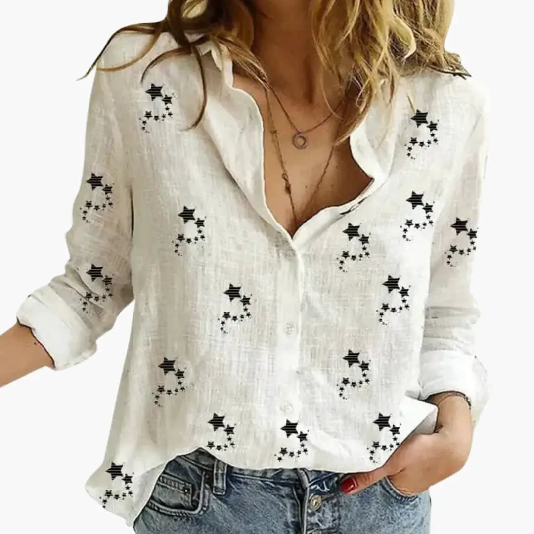 Elegant floral pattern blouse by Wilfred Smith, white linen with black star motifs and rolled sleeves.