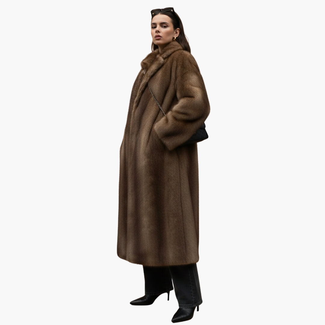 Women's brown fur coat with stand-up collar and long sleeves on model, paired with black pants and boots