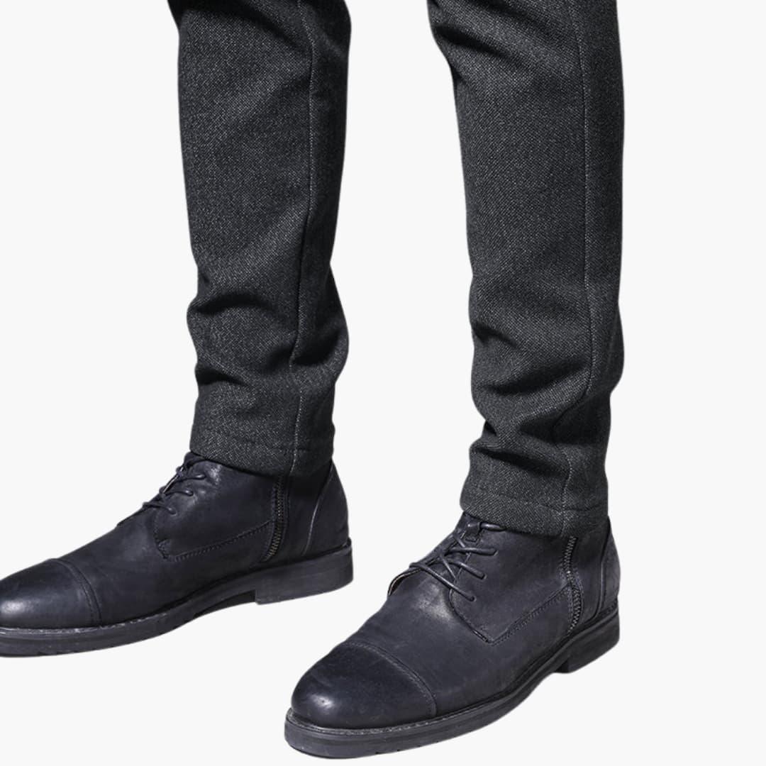 Casual trousers for men in dark gray with a textured finish, paired with black leather lace-up boots.