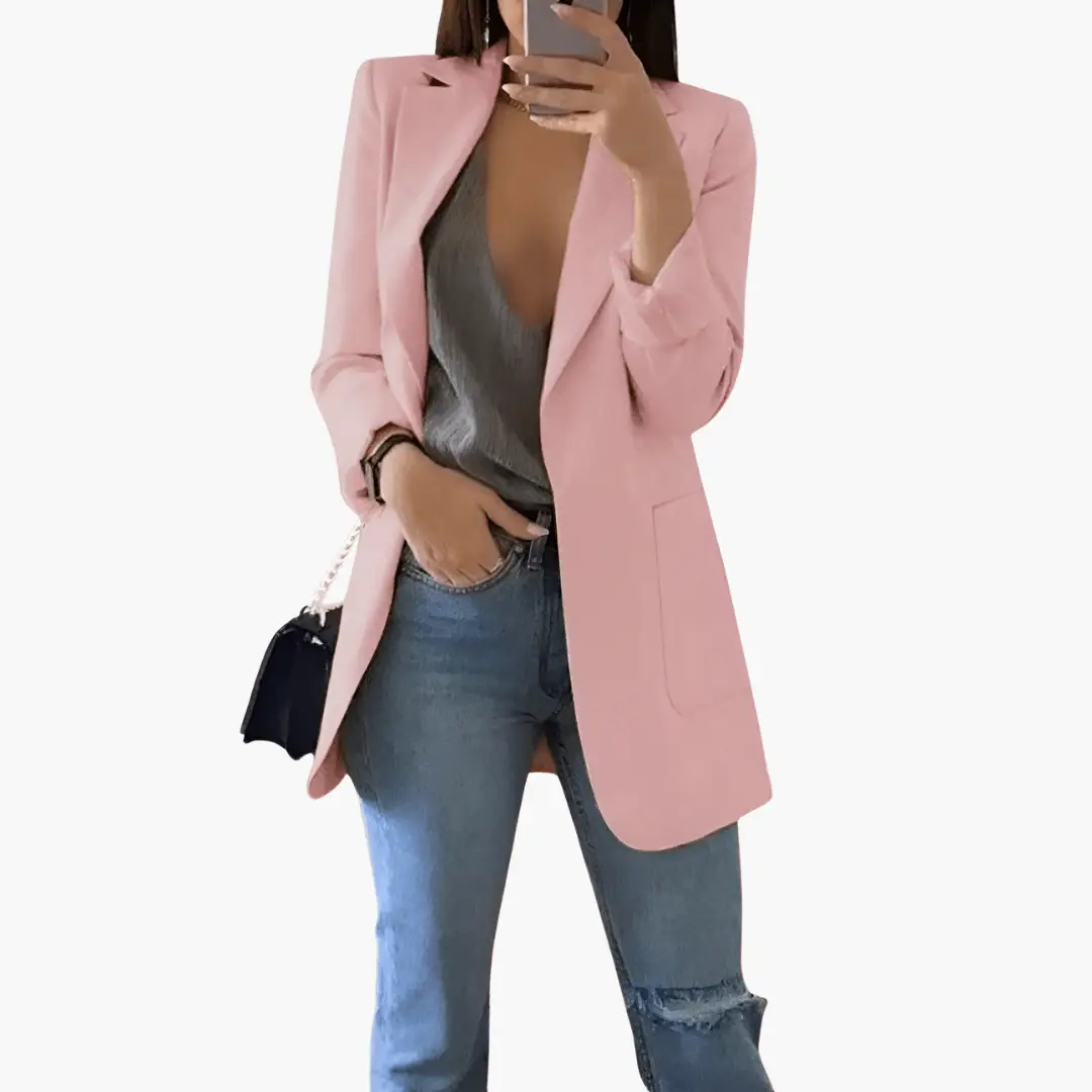 Women’s pink blazer with open front and long sleeves worn over a gray top and blue jeans