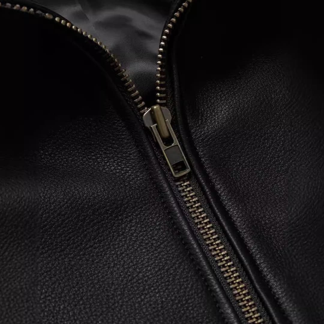 Men's jacket with zipper, black pebbled leather close-up of a metal zipper