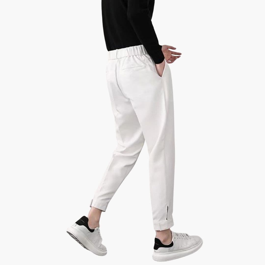Men's white tapered trousers with side pockets and button closure, elastic waistband