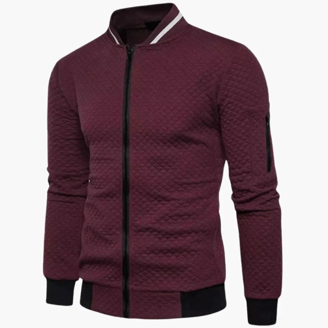 Men’s burgundy quilted bomber jacket with zip front, ribbed cuffs and hem, and left-sleeve zip pocket.