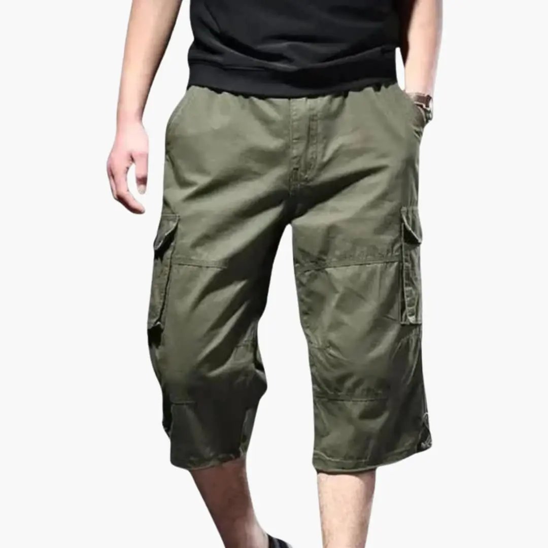 Men's cropped cargo pants in olive green with multiple pockets and a loose fit.