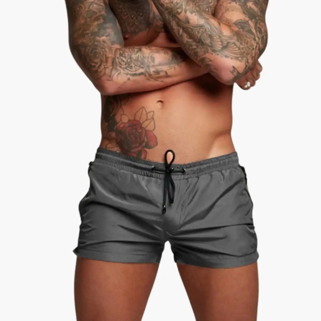 Men’s gray jogger shorts with elastic waistband, drawstring, and zippered pockets.