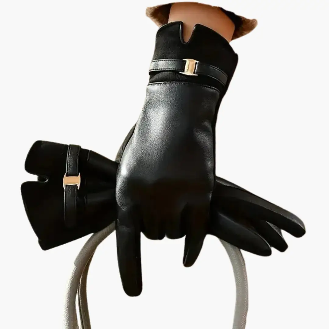 Pair of women’s full-finger black leather gloves with a gold-tone decorative strap by Wilfred Smith