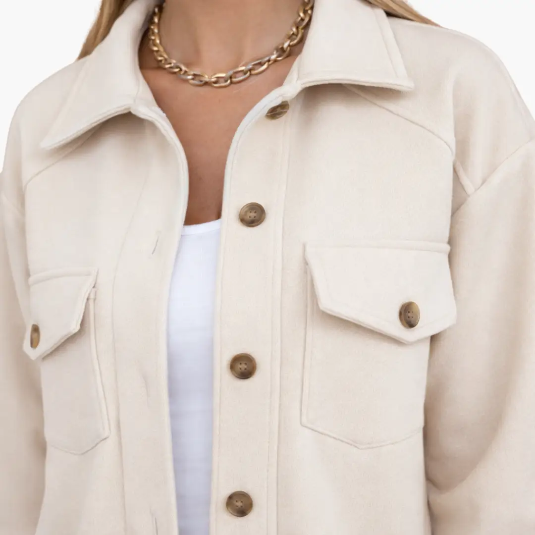 Women’s jacket in cream with brown buttons and chest flap pockets.