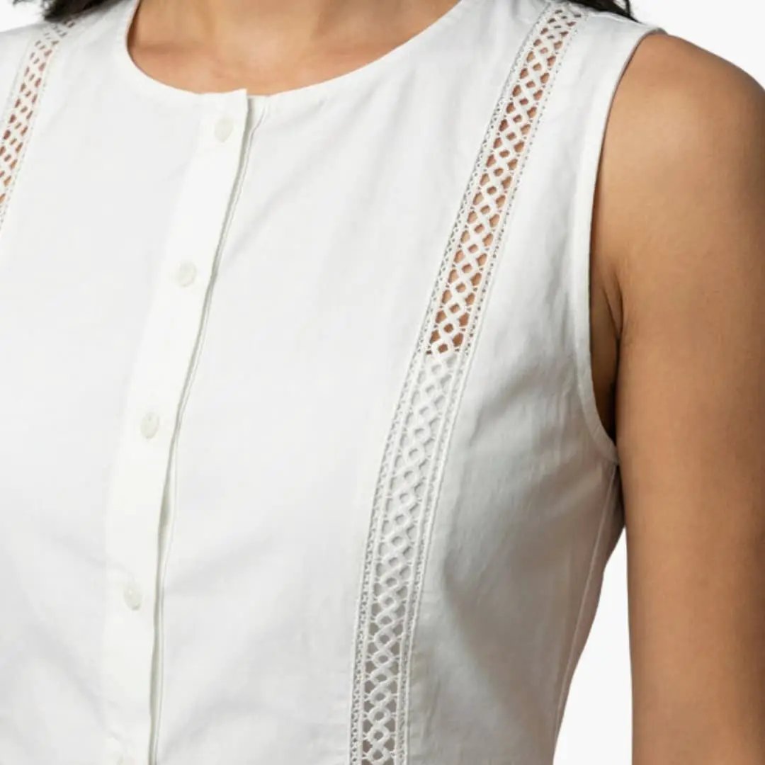 Women's mini dress by Wilfred Smith, white sleeveless with round neck and lace side panels.