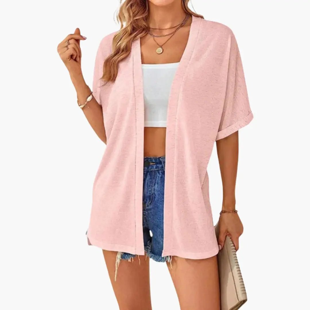 Women's open-front pink cardigan with short sleeves, layering top over white crop top and denim shorts