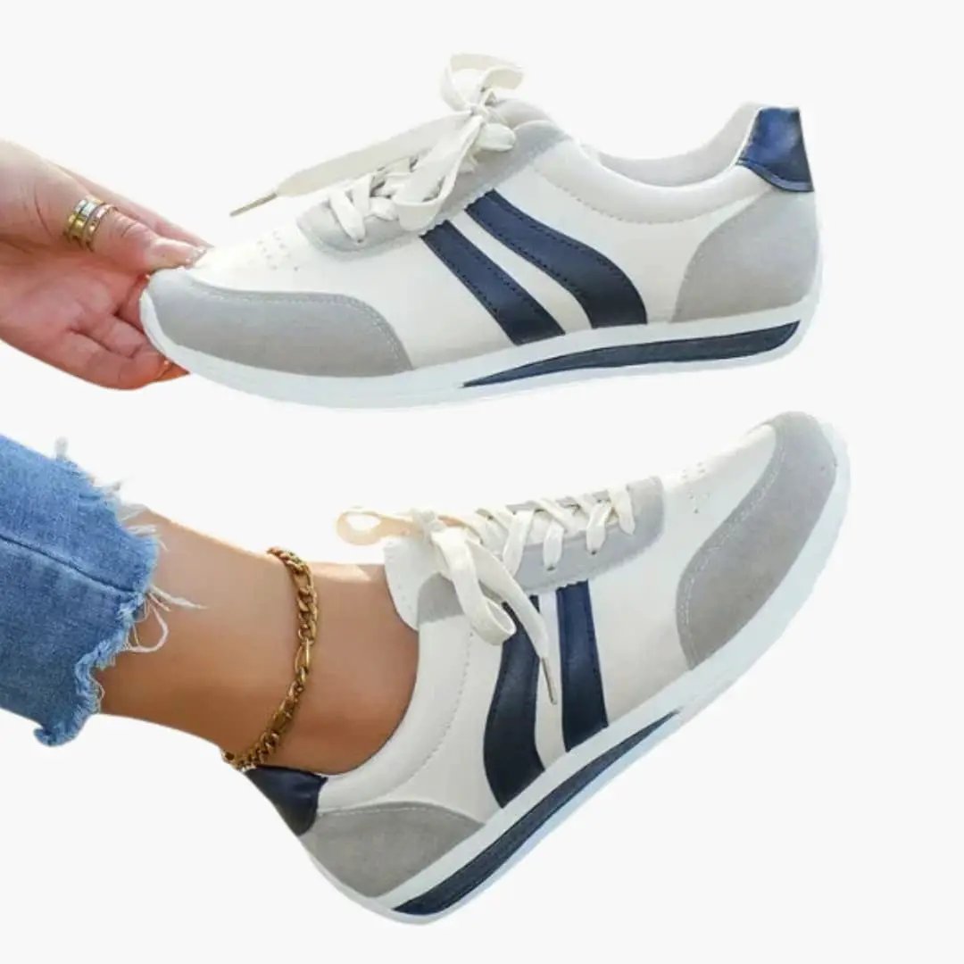 Pair of women's orthopedic athletic shoes with breathable white upper, blue stripes and rubber sole