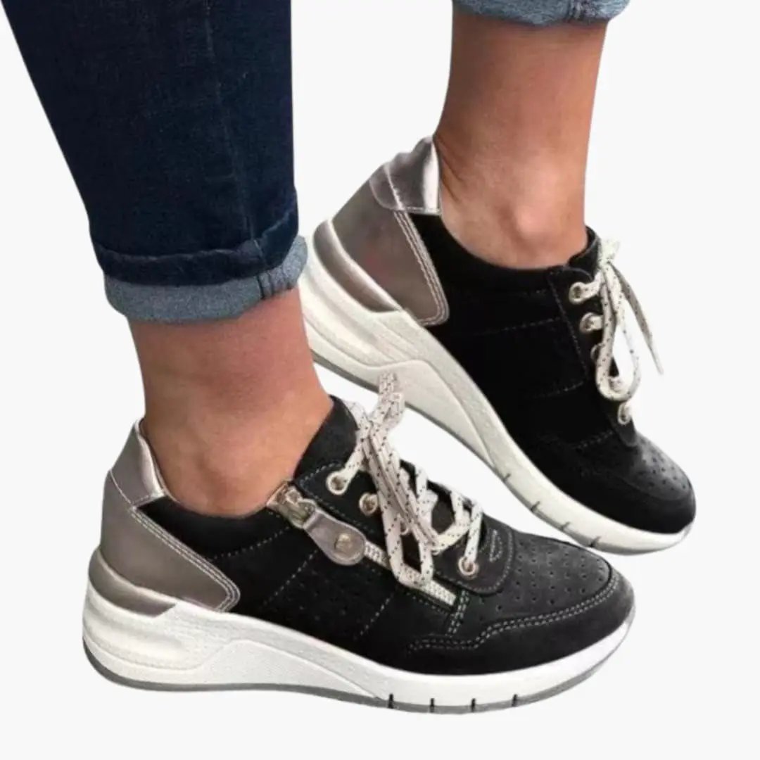 Pair of women's orthopedic sneakers with cushioned sole, black and gray upper, lace closure, white sole.