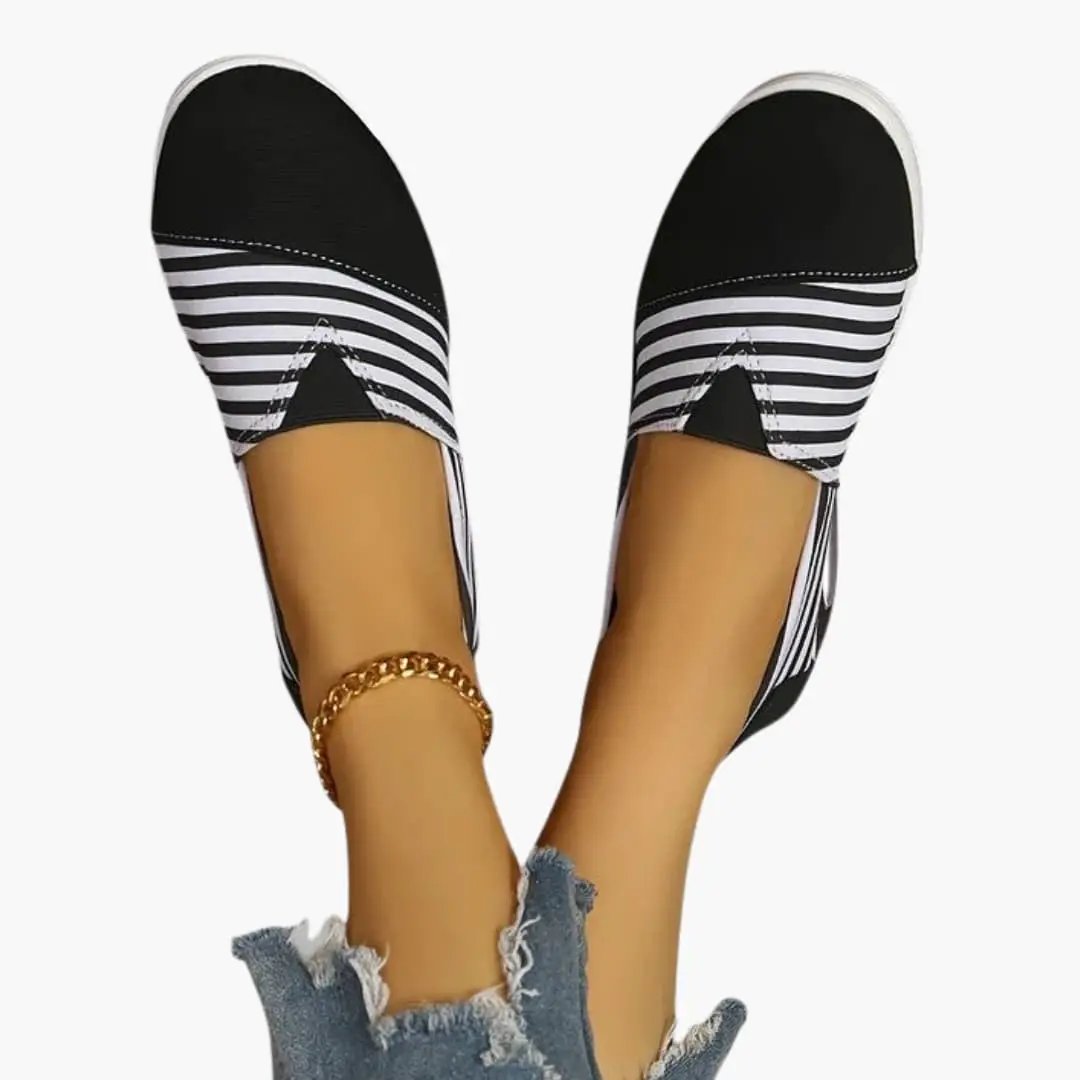 Women's orthopedic slip-on sneakers with black-and-white striped upper and textured sole.