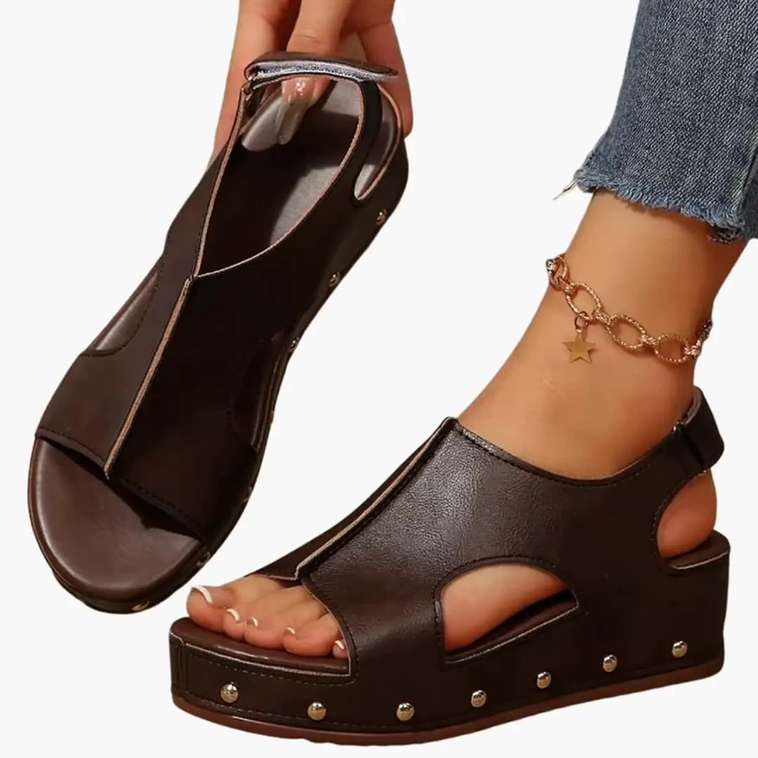 Pair of women's platform sandals with cushioned footbed, brown with cutout sides and studded wedge