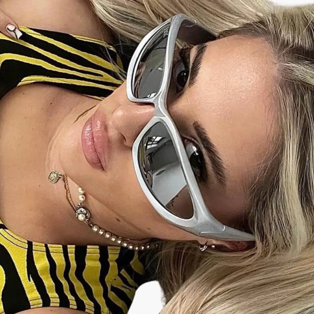 Women's sunglasses with light grey cat-eye frame, metal detailing, and dark lenses.