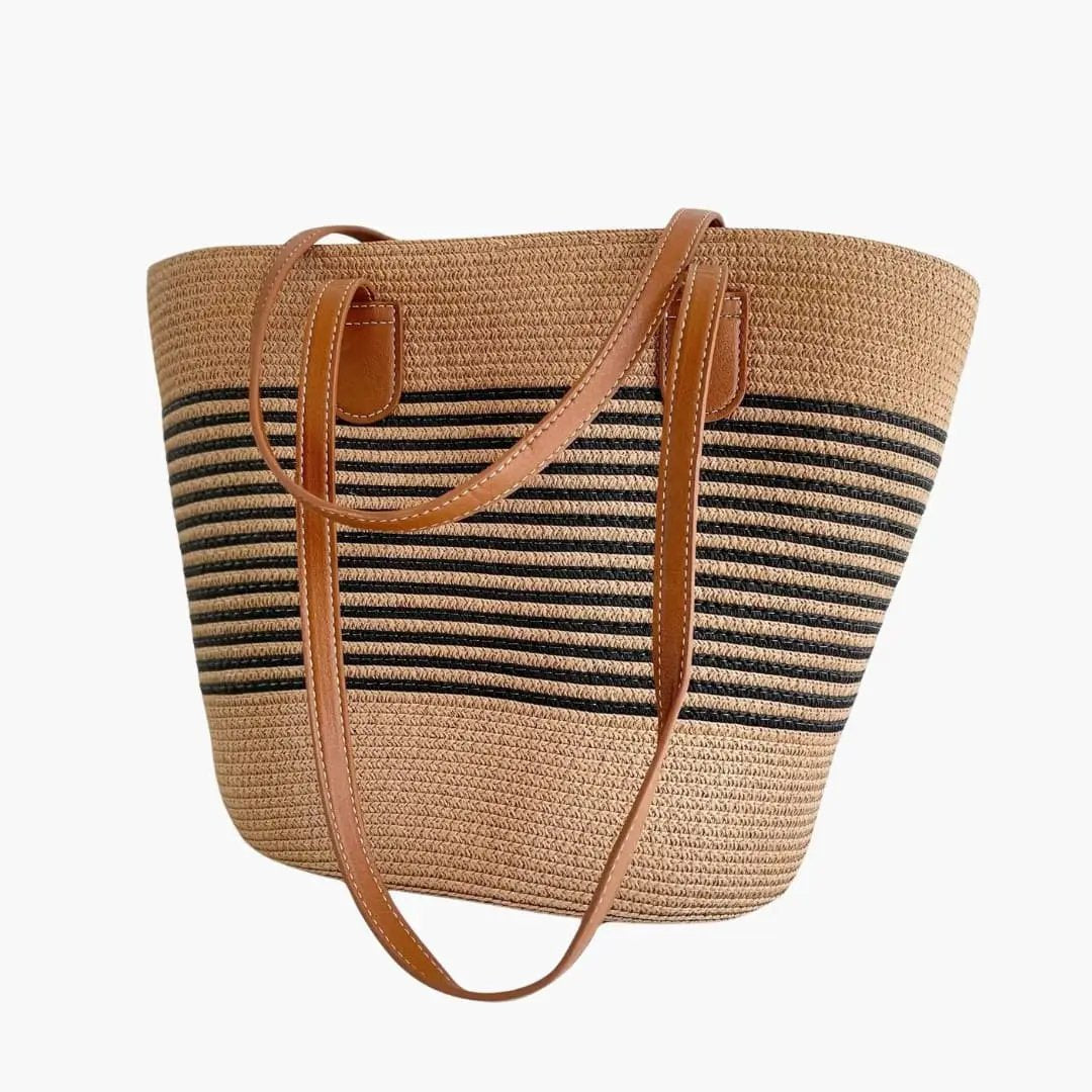 Women's tote bag made of straw with black stripes and tan leather shoulder straps