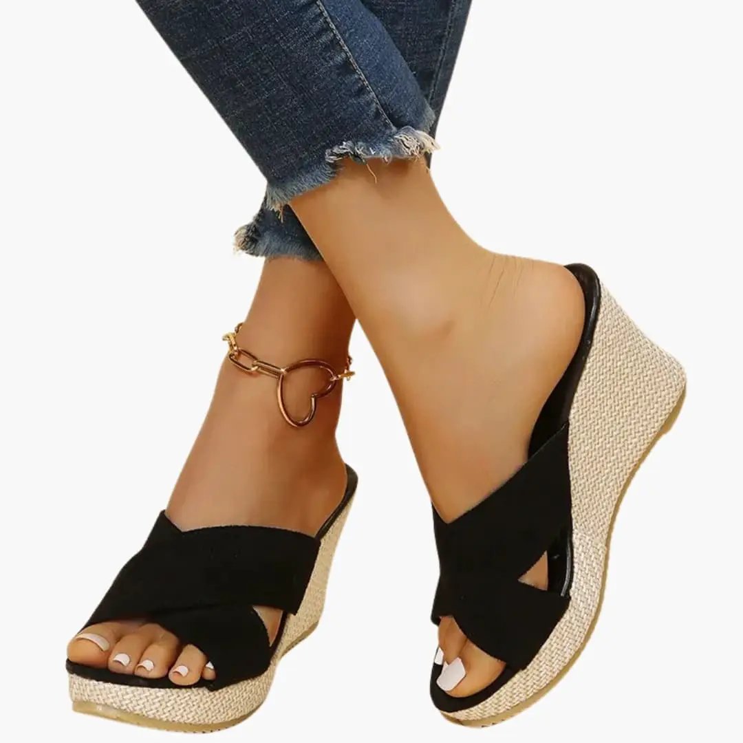 Women's wedge sandals with black crisscross straps, open toe, and natural jute-wrapped wedge heel.