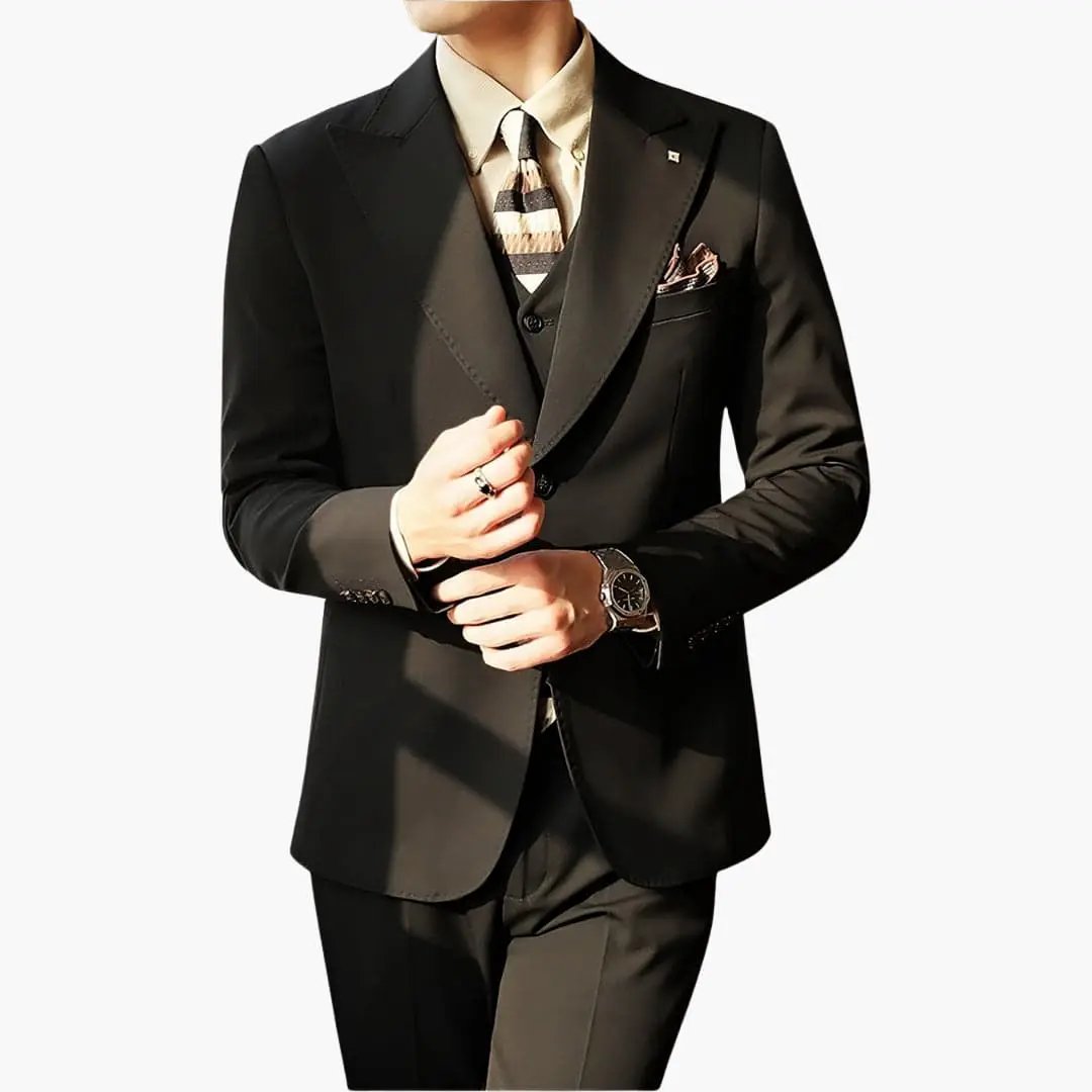Men's three-piece black suit by Wilfred Smith with vest and slim-fit cut, beige shirt and striped tie