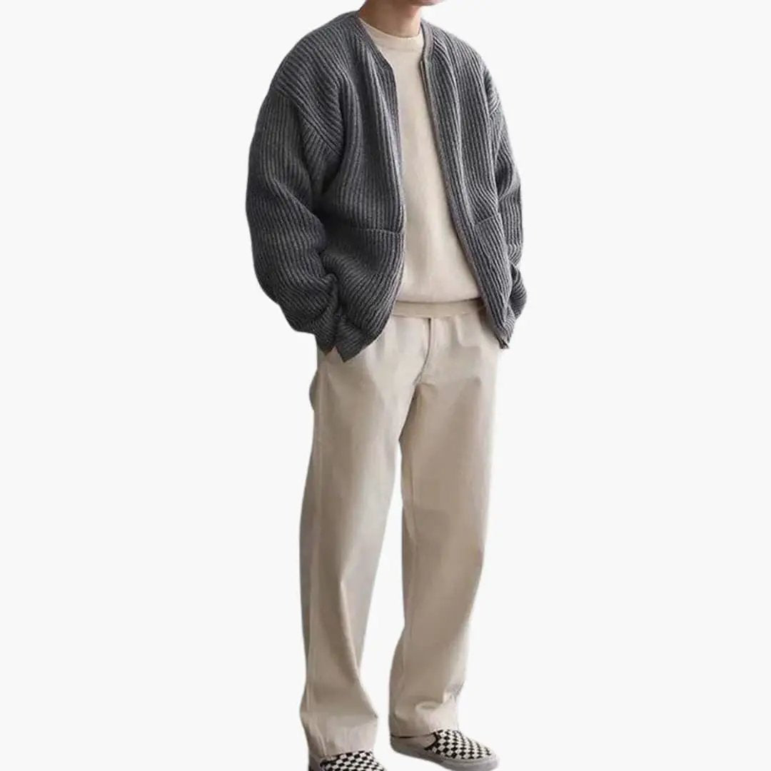 Men's gray chunky-knit cardigan worn over a beige top and light khaki pants