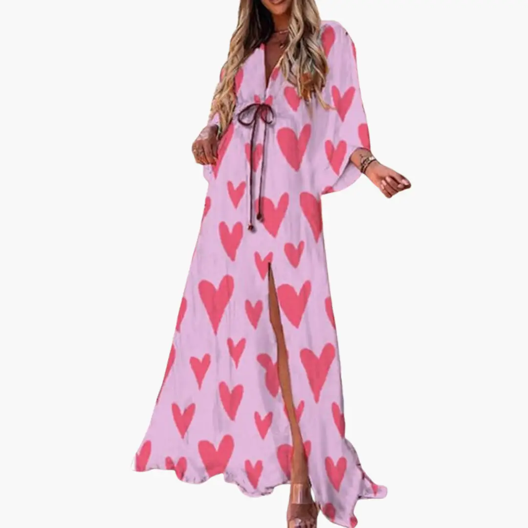 Colorful women's pink maxi dress with red heart print, tie waist, and front slit.