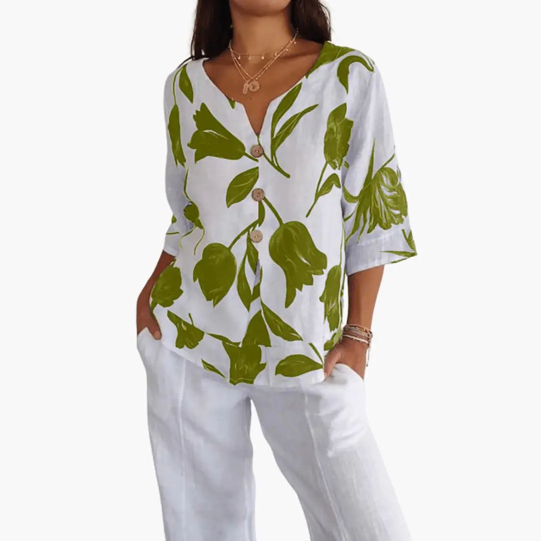 Women's floral print V-neck blouse in white with green leaves; button-front top, two-piece set with white pants.