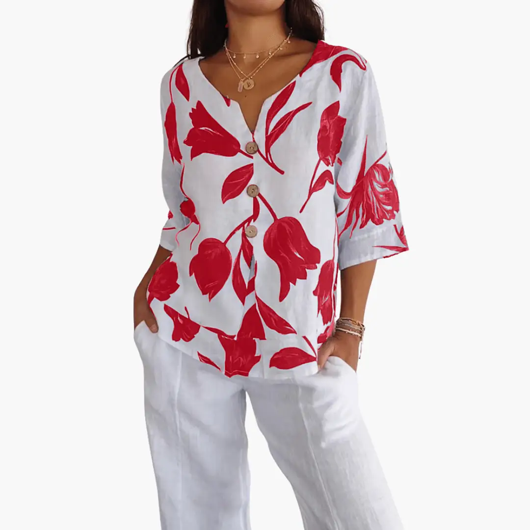 Women's floral print V-neck blouse in white with bold red botanical pattern and wooden buttons