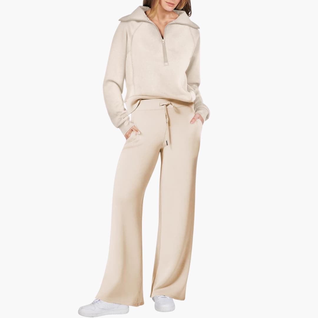Women's two-piece beige loungewear set with a half-zip fleece top and wide-leg pants.