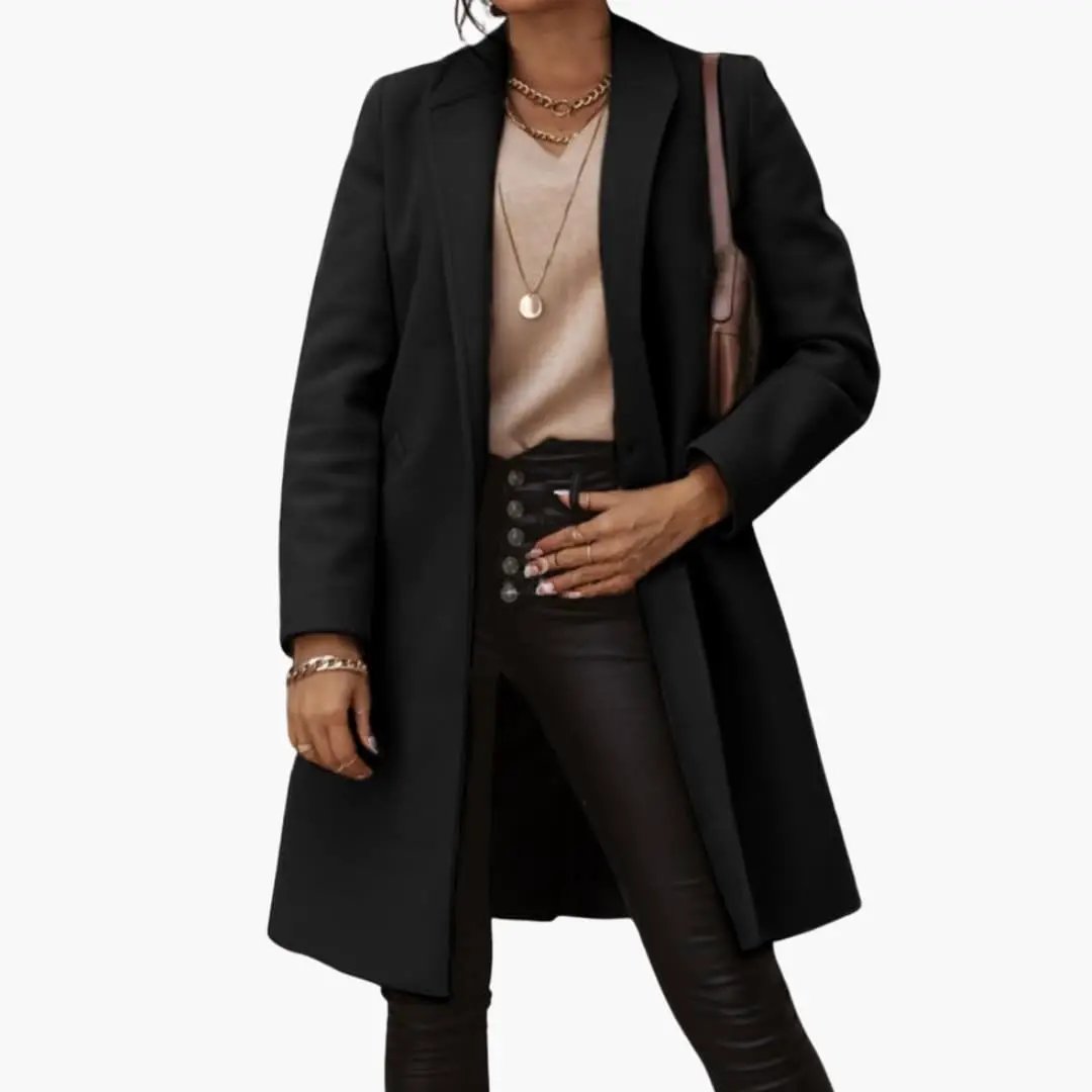 Women's long black coat with collar and buttons, model wearing beige top and black pants