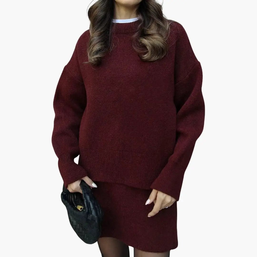 Women's burgundy knit two-piece set with round-neck sweater and matching skirt by Wilfred Smith.