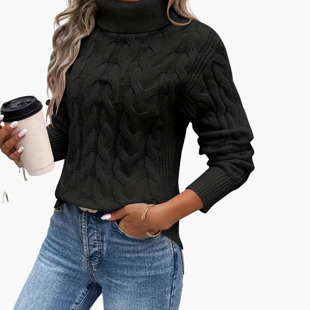 Women's black cable-knit turtleneck sweater by Wilfred Smith, paired with blue jeans worn by a model.
