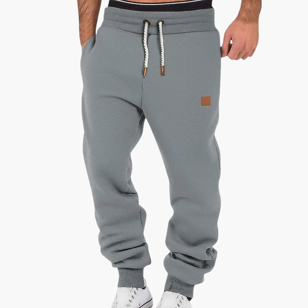 Men's jogging pants in gray with pockets and drawstring waistband, Wilfred Smith logo patch.