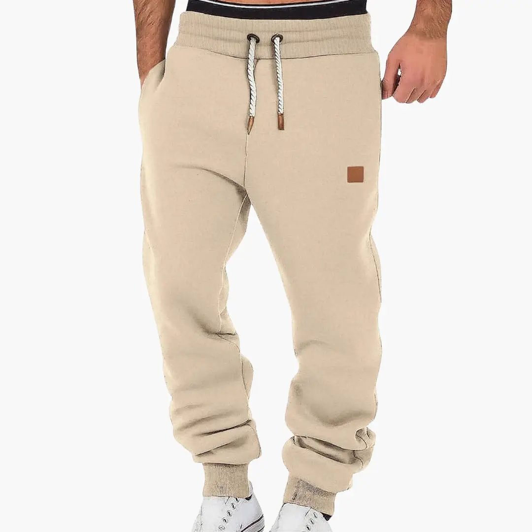 Men's beige joggers with pockets and drawstring waistband, elastic cuffs.