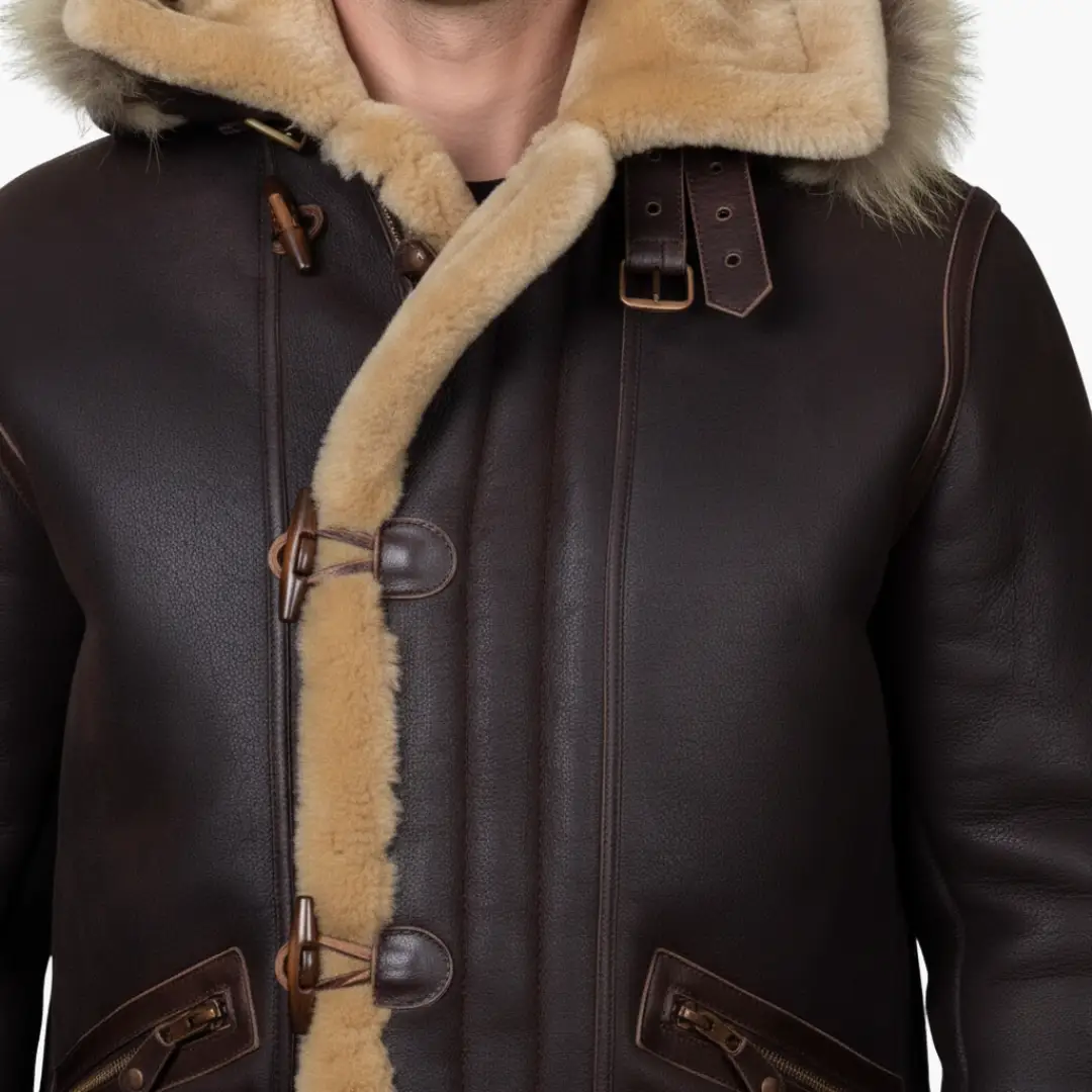 Men's brown leather parka with hood, tan shearling trim, and toggle closures.