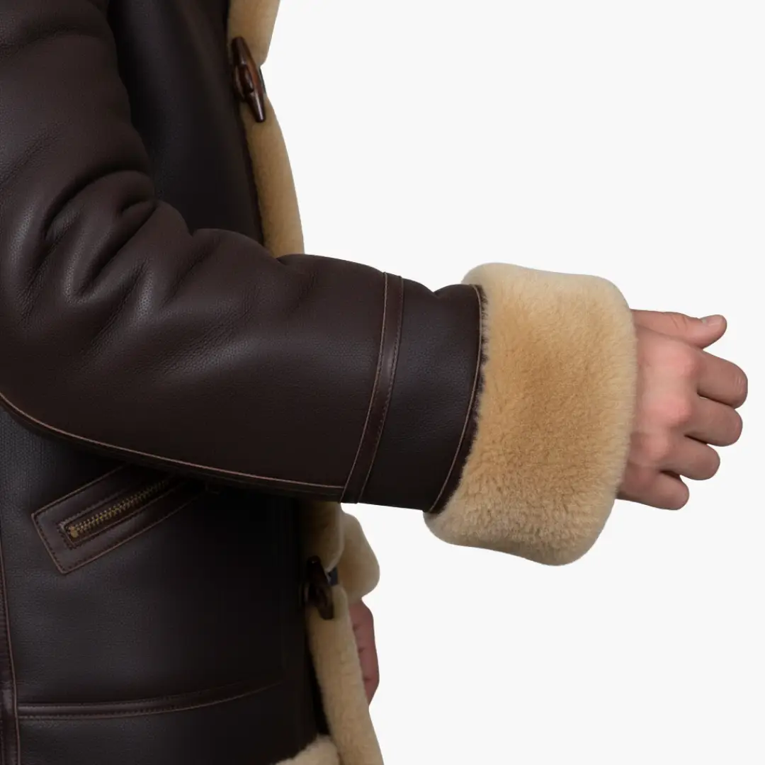 Men's jacket with hood and toggle closure in dark brown leather with beige shearling cuffs
