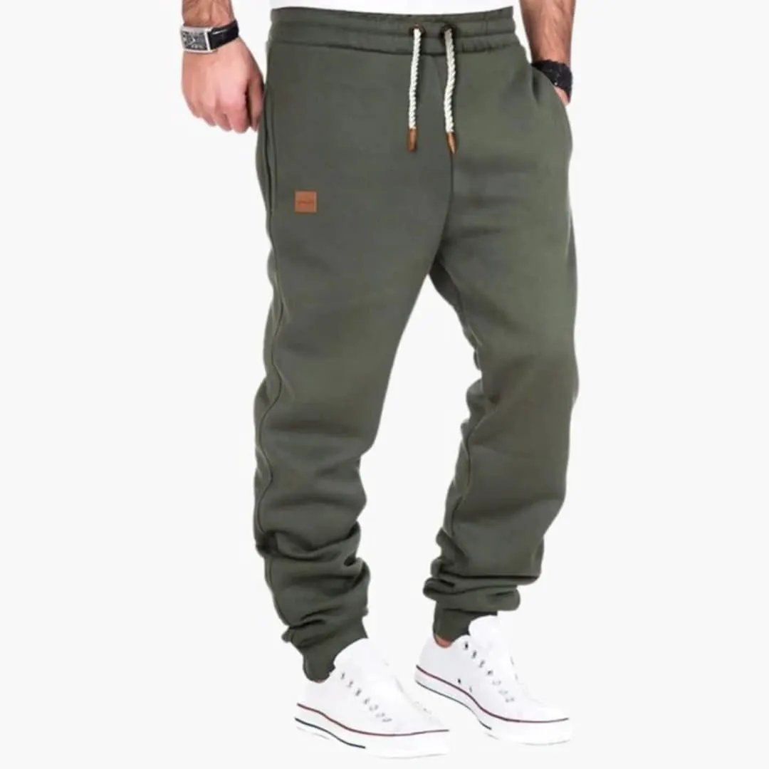 Men’s Jogger Pants by Wilfred Smith in olive green with ribbed cuffs, drawstring waist and pockets.