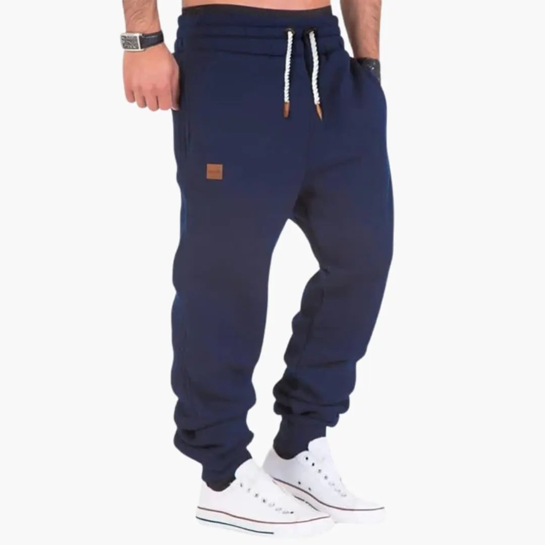 Men's jogger pants by Wilfred Smith, navy blue with ribbed cuffs, drawstring waist and pockets.