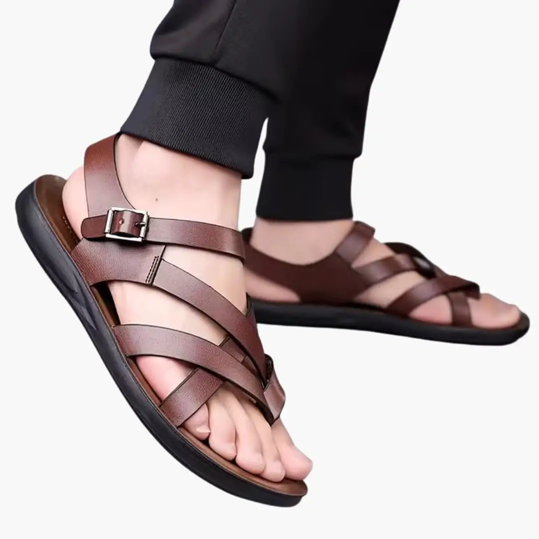 Brown leather men's Roman sandals with crisscross straps and buckle, slip-on open-toe.