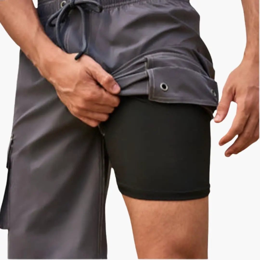 Men’s stretch swim shorts by Wilfred Smith, dark gray mid-length boardshorts with inner lining and side cargo pocket.