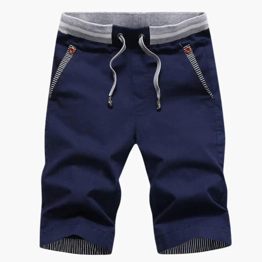 Men's jogger shorts by Wilfred Smith in navy, knee-length, elastic waist with gray drawstrings and striped turn-up hems.