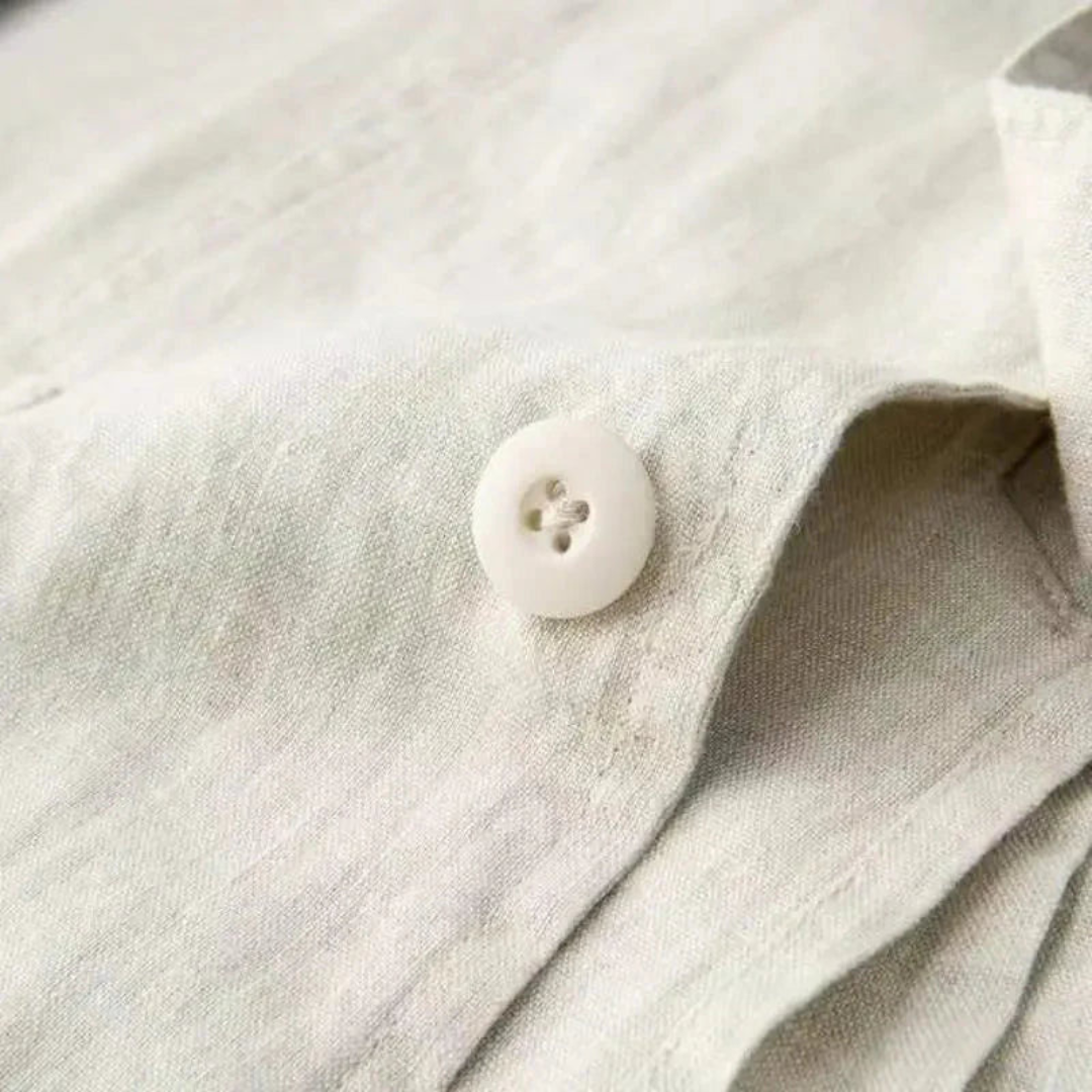 Men's blazer button close-up on light beige fabric, part of a two-piece suit