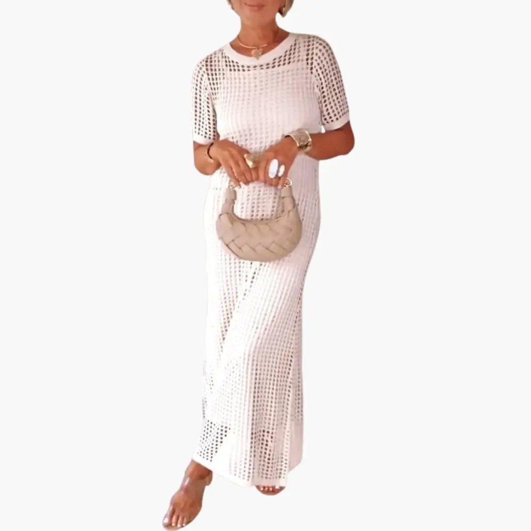 Women's long white crochet dress with cut-out mesh panels and inner lining; beige woven handbag.
