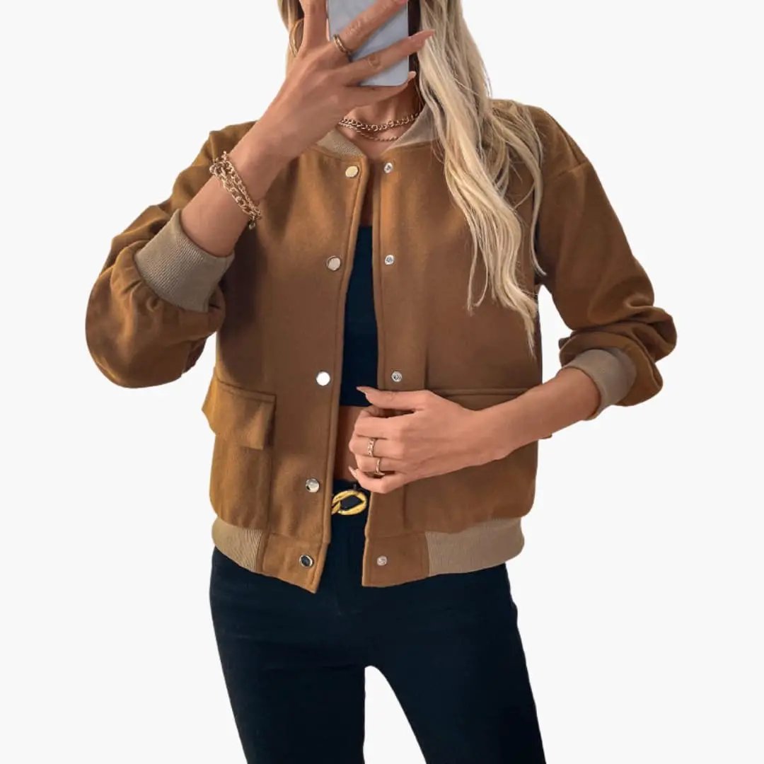 Women’s bomber jacket in tan brown with snap button front, ribbed cuffs and hem, and side pockets.