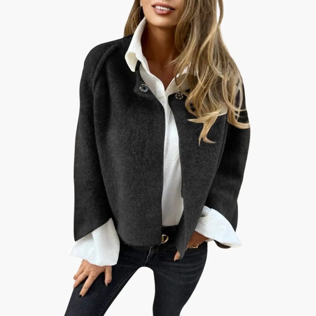 Women’s cropped bolero jacket in black wool, styled over a white blouse.