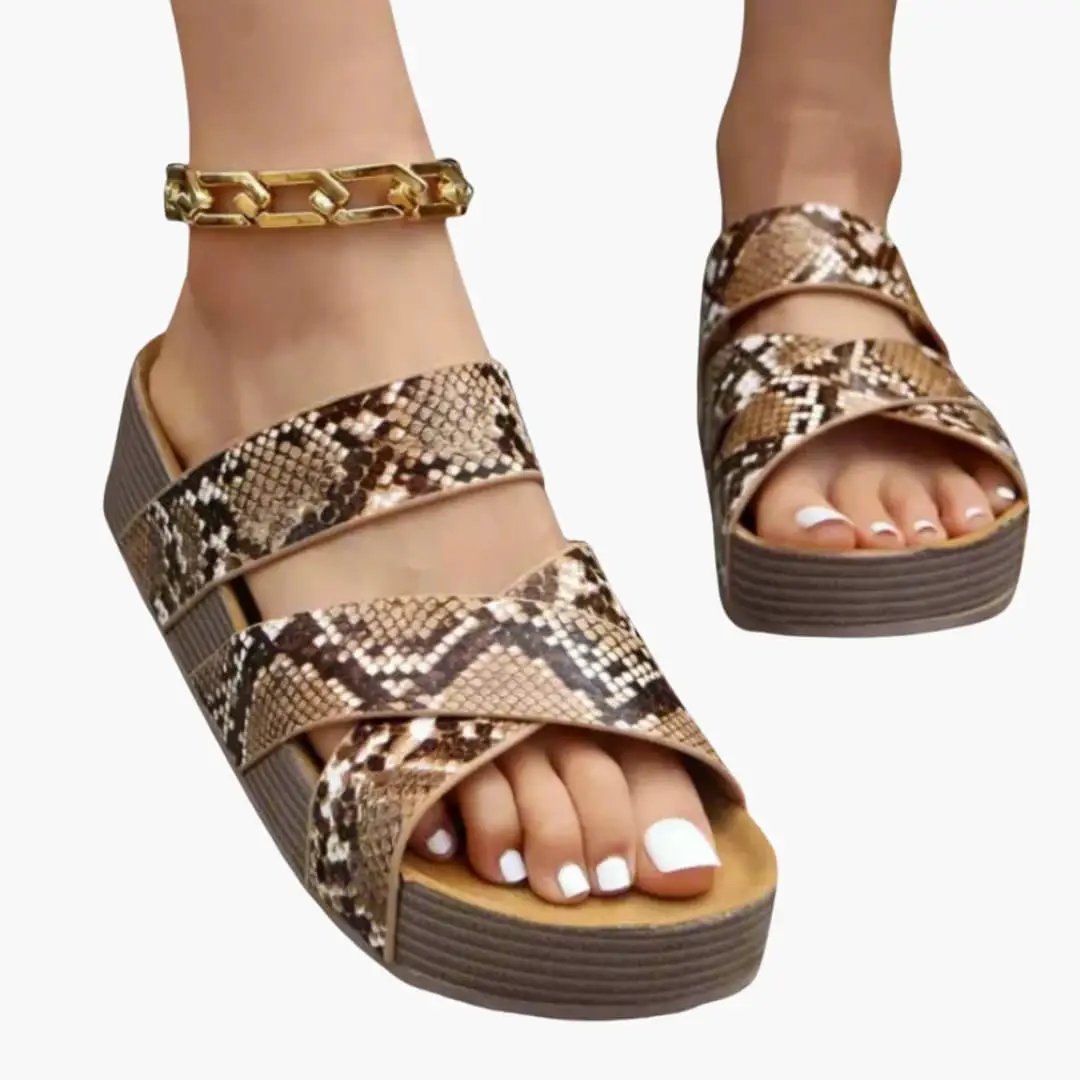 Pair of women's orthopedic sandals with snake-print straps, cushioned insole and flexible sole.