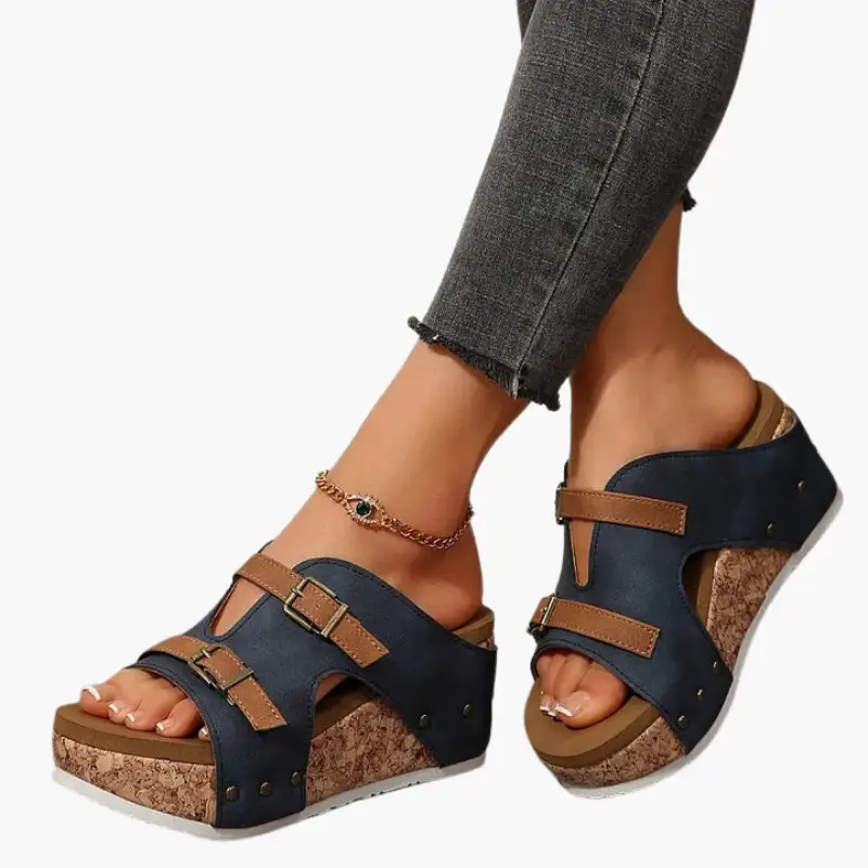 Women’s orthopedic sandals with wedge cork sole, navy blue upper and tan adjustable straps by Wilfred Smith.