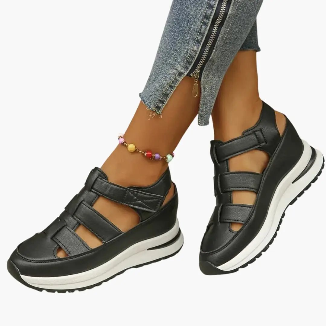 Pair of women's orthopedic sandals with adjustable straps, black uppers and textured sole