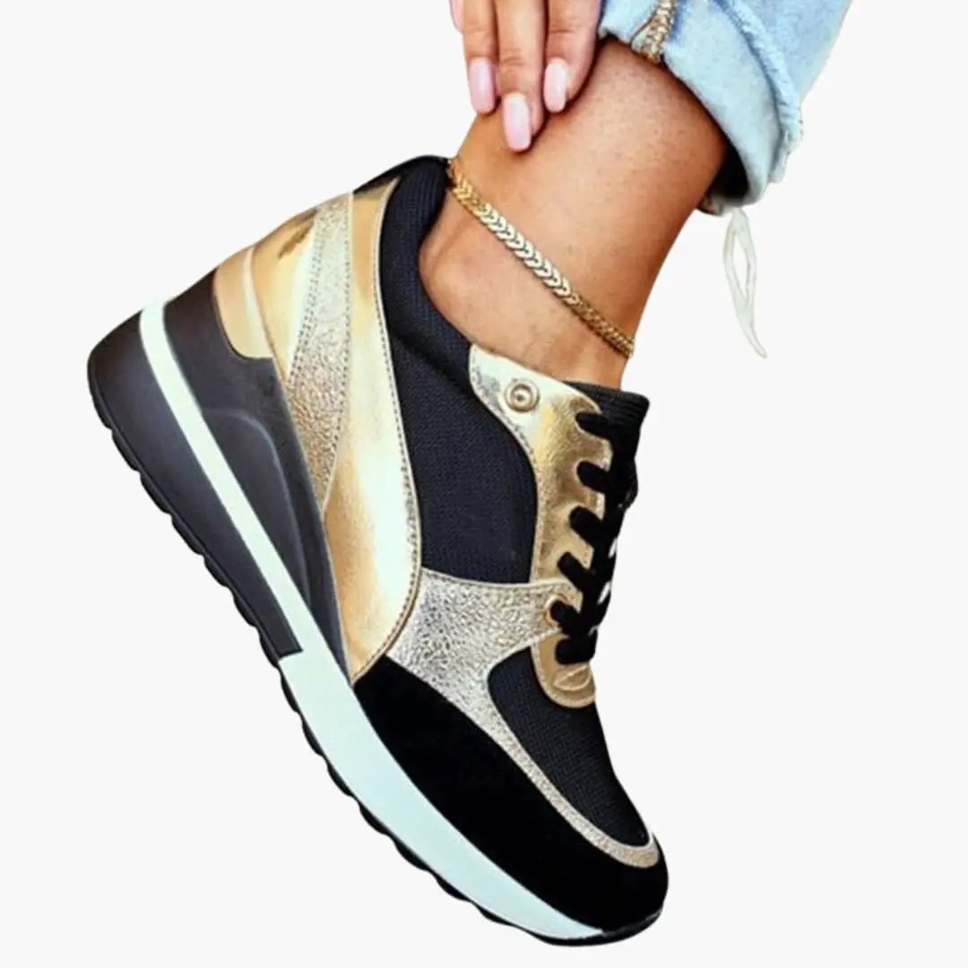Women's orthopedic sneaker by Wilfred Smith with cushioned sole and lift-insole, black mesh with gold accents.